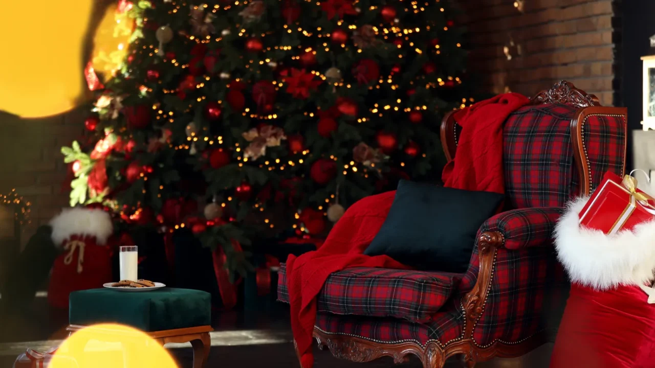 Santa Claus bag near armchair in room with Christmas tree.