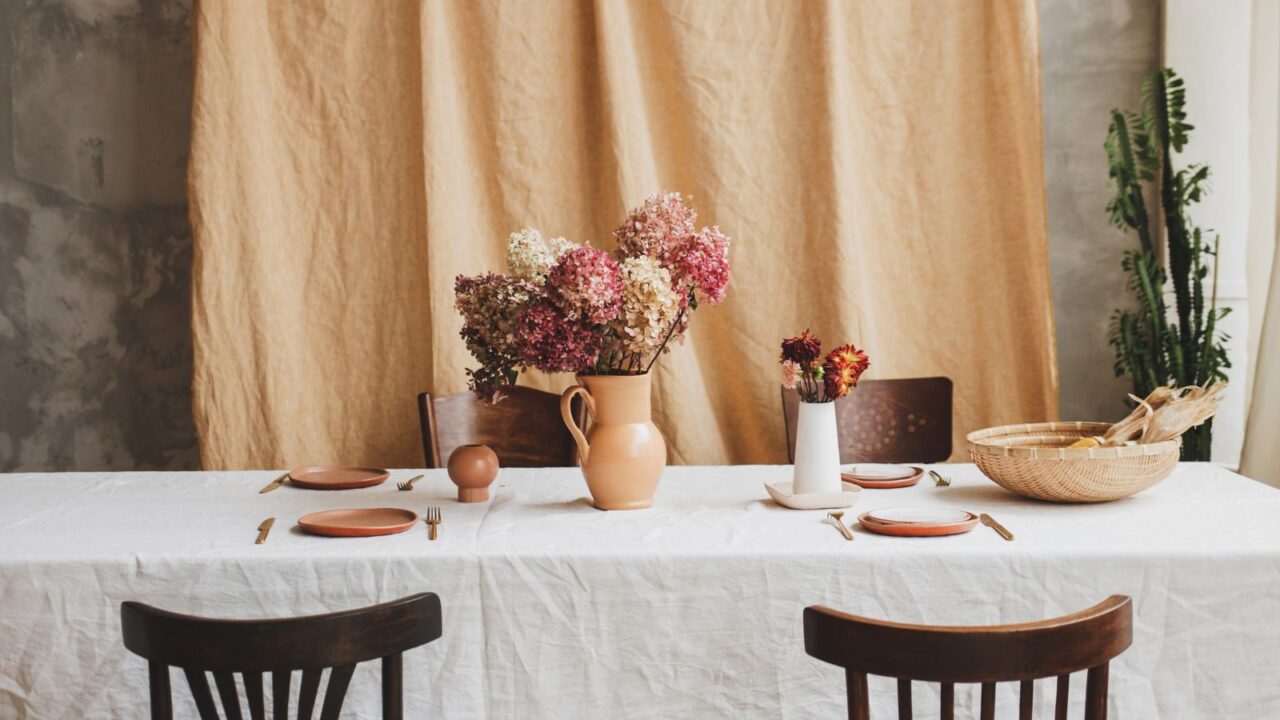 Vintage table with rustic dishes. Classic European interior. A vase with dried hydrangeas on a dining table.