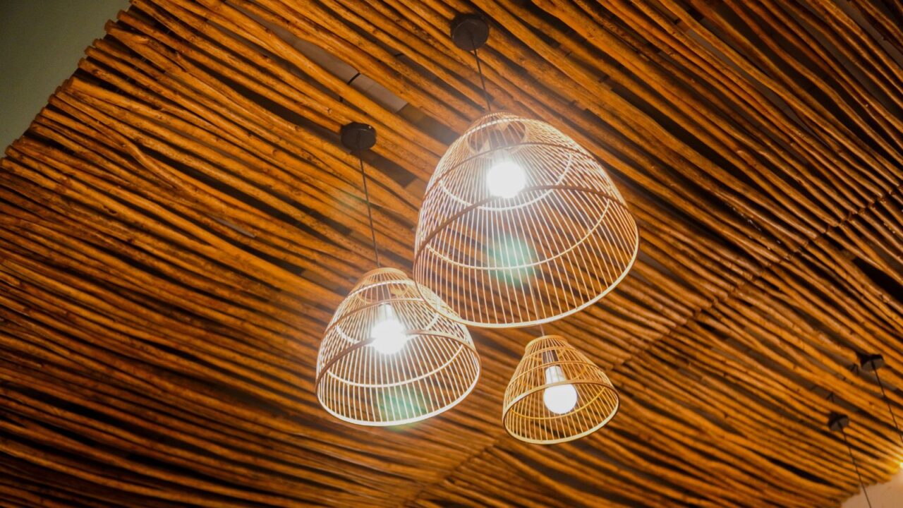 Decorative lamps made of rattan with warm colors hanging from a bamboo ceiling.