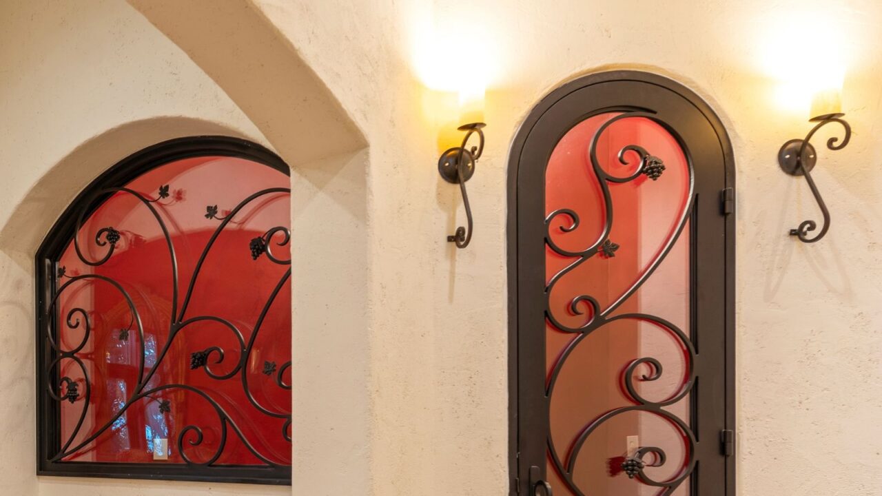 Elegant entrance with wrought iron sconces and features and warm lighting.