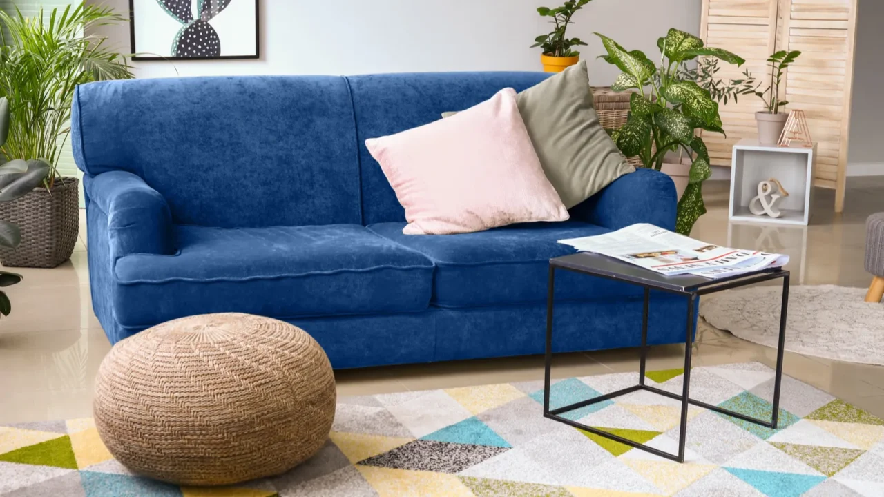 stylish interior of room with blue sofa and green houseplants