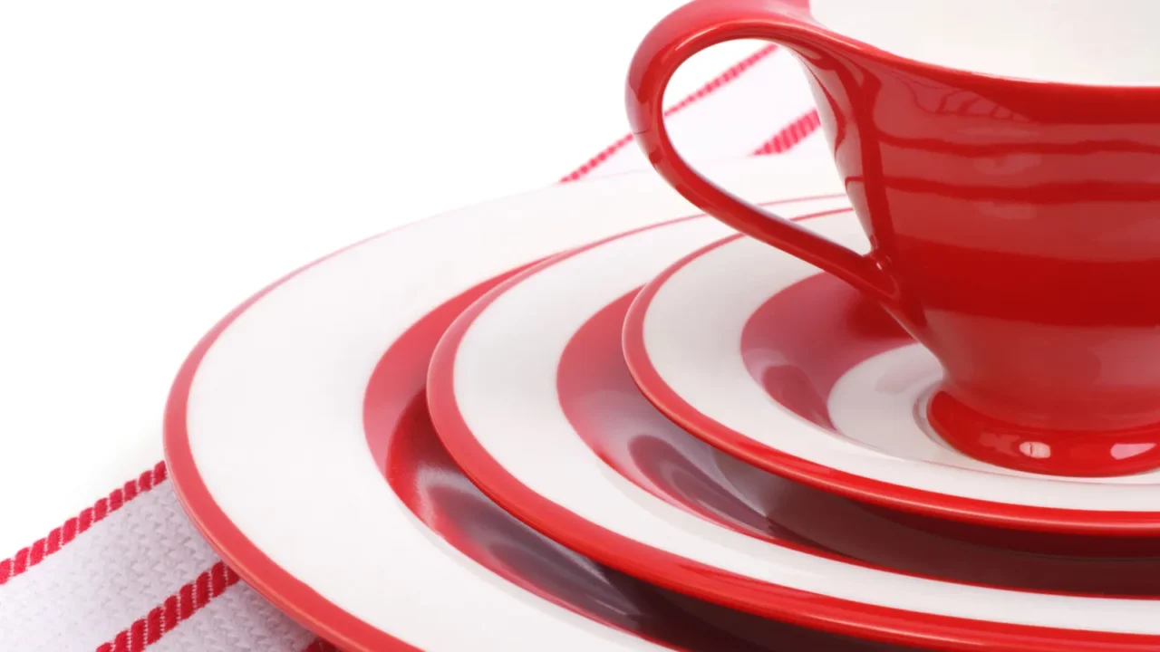 table setting red plates and cups for tea on striped