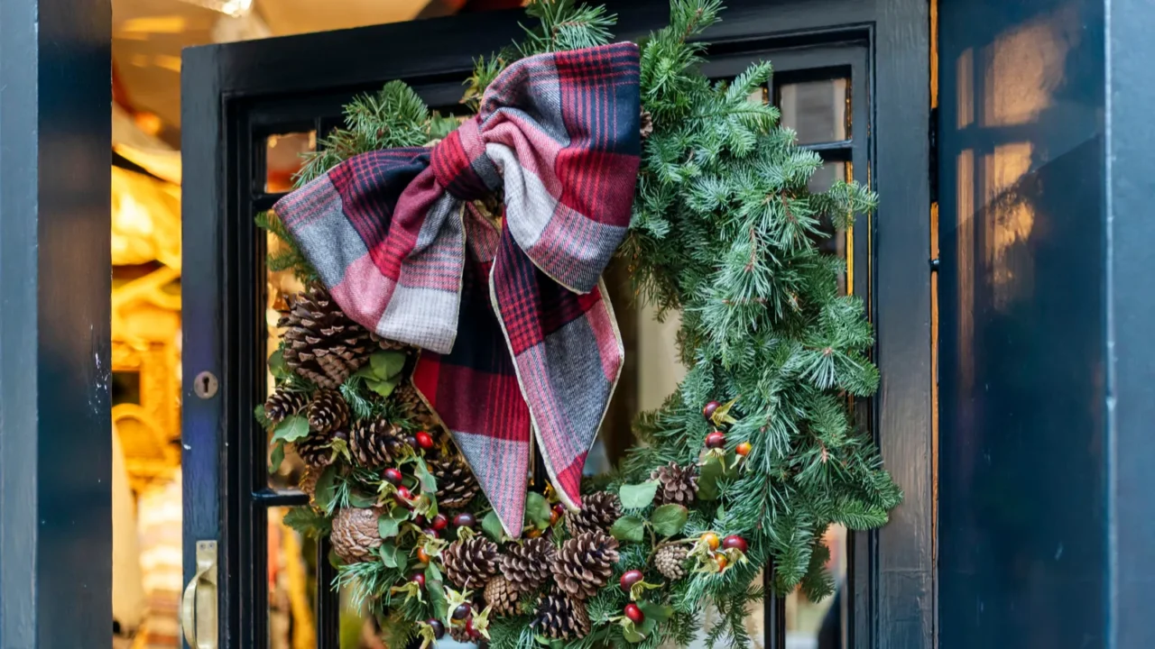 traditional christmas wreath with plaid bow pinecones and red berries