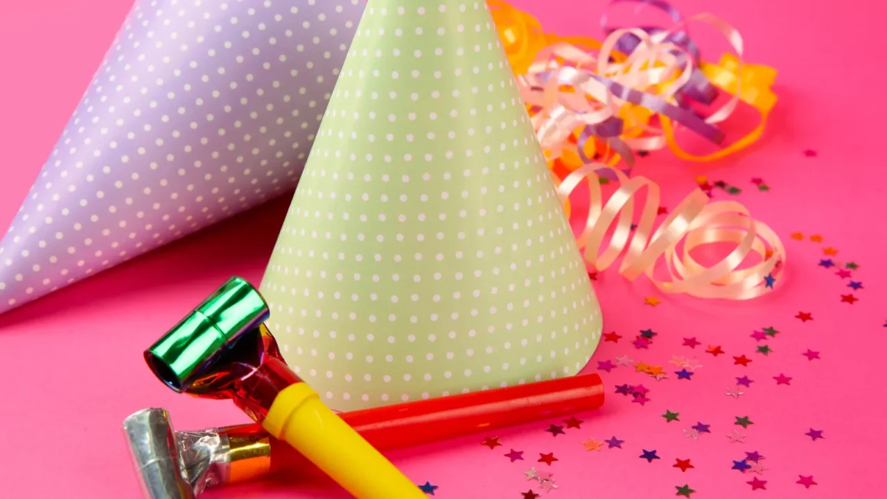 two dotted birthday hats with serpentine streamer and noise makers