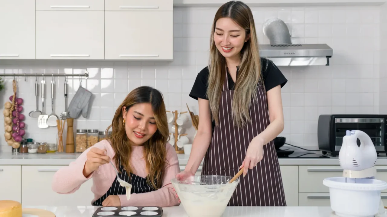 two young women make dessert in the kitchen one people