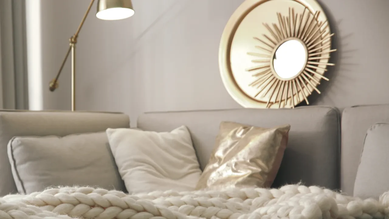 warm knitted blanket on grey sofa in living room interior