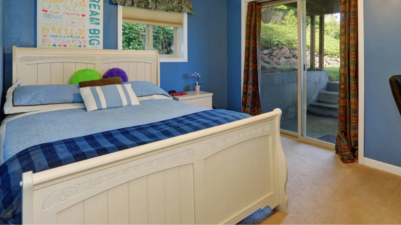 white carved wooden double bed in blue bedroom