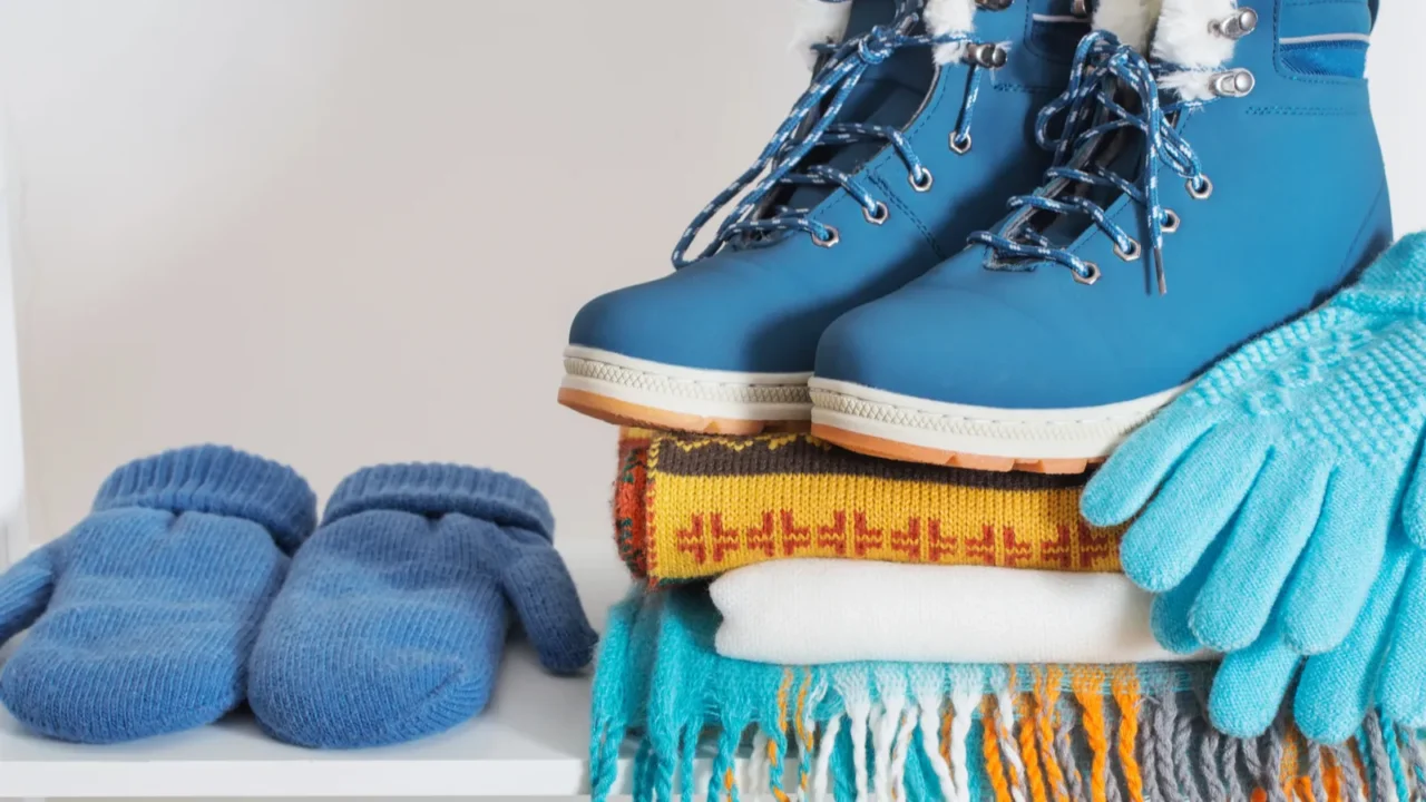 winter shoes gloves and scarf on white wooden shelf