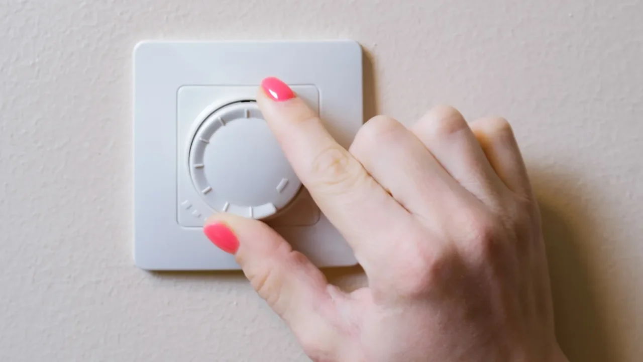 womans hand adjusts the lighting with a dimmer lever an