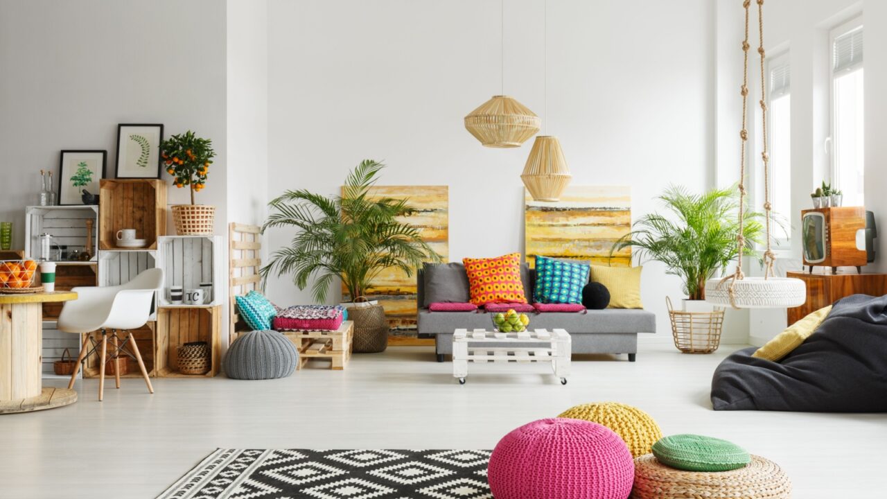 A lively space with a mix of colorful cushions, wooden crates, and plants.