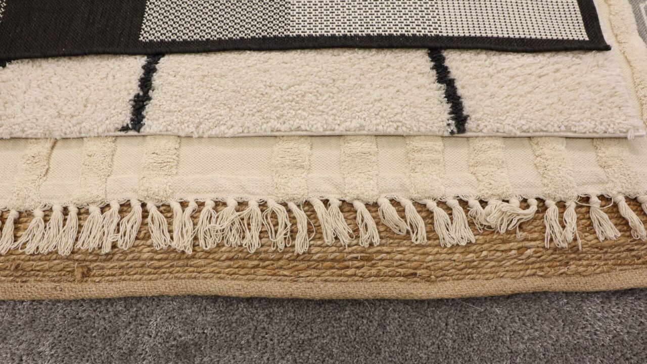 Different textured rugs layered together.