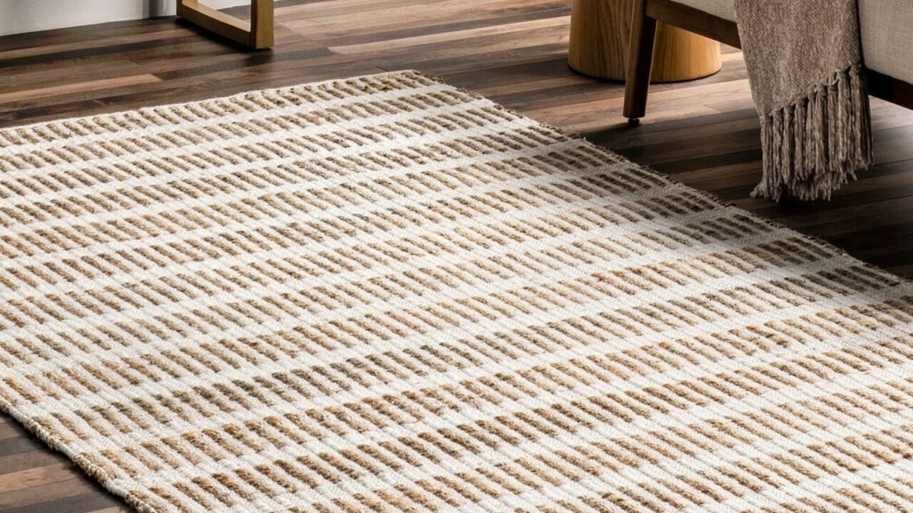 A handwoven jute area rug on a wooden floor.