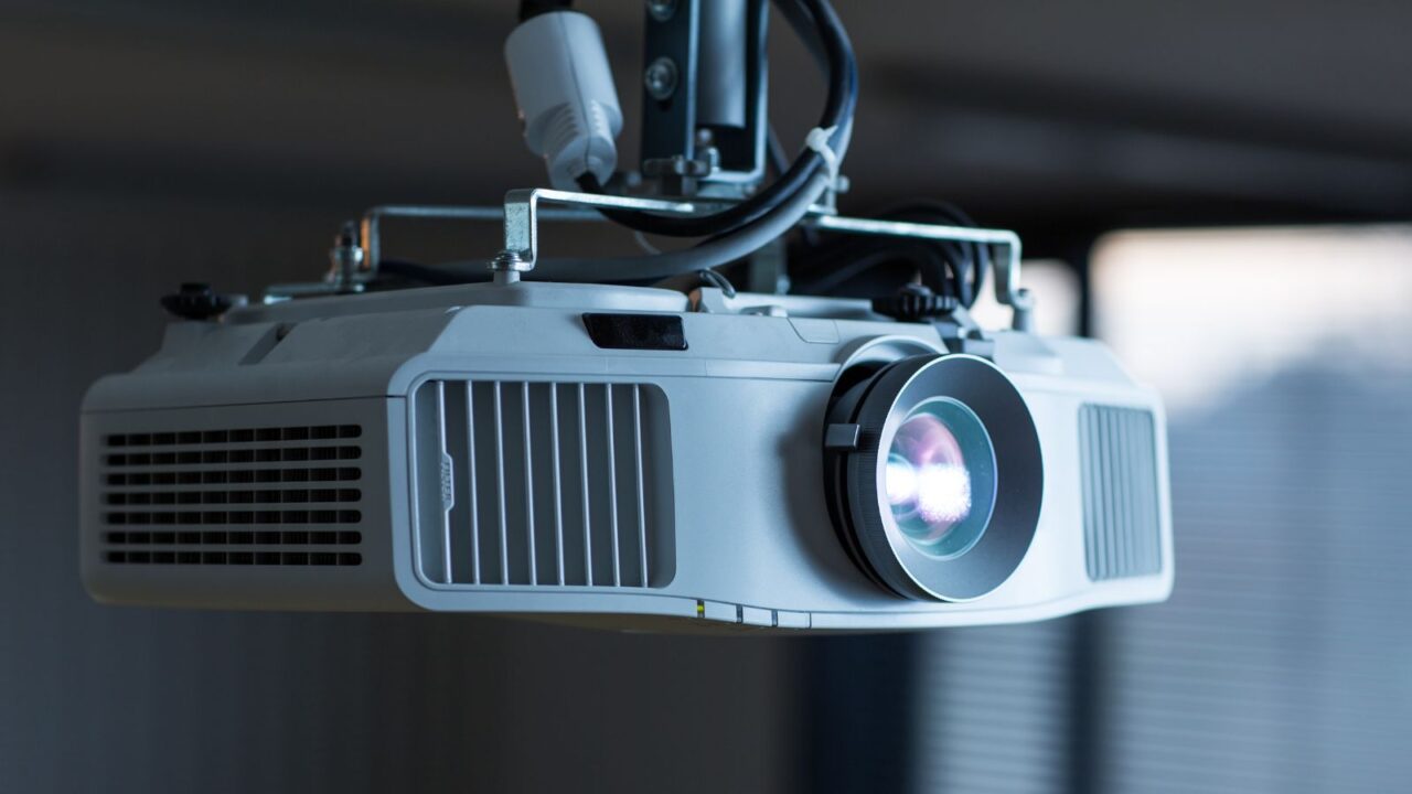 A modern laser projector hanging from the ceiling.