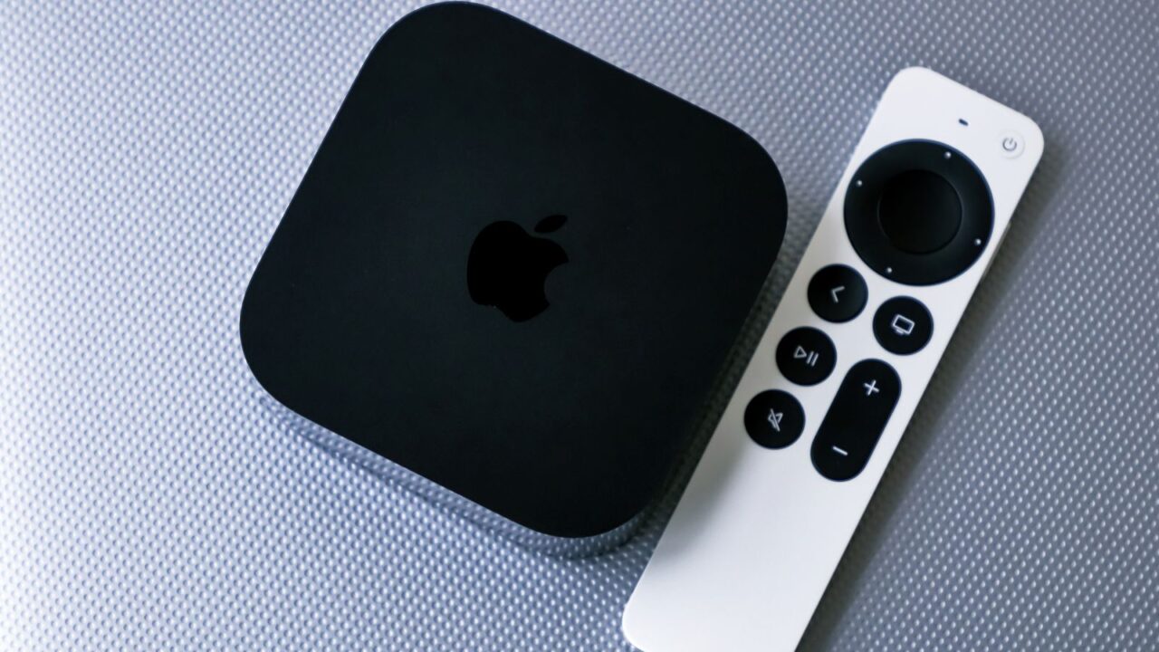 An Apple TV streaming device on a gray background.