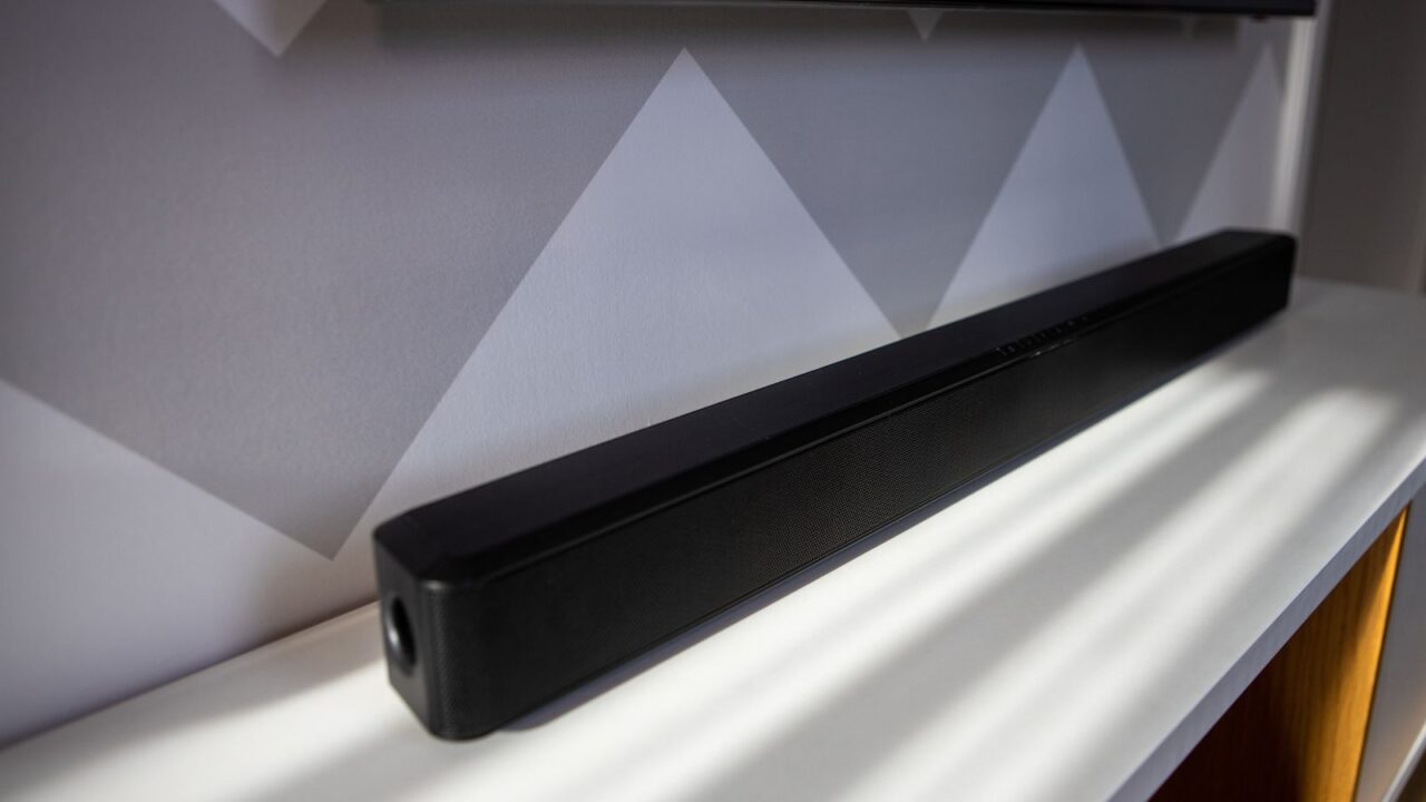 A Dolby soundbar on a white console table.