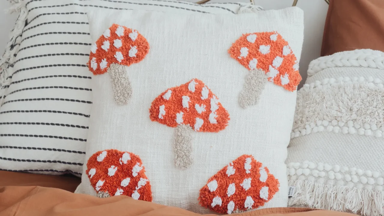 a bed adorned with a unique mushroompatterned cushion surrounded by