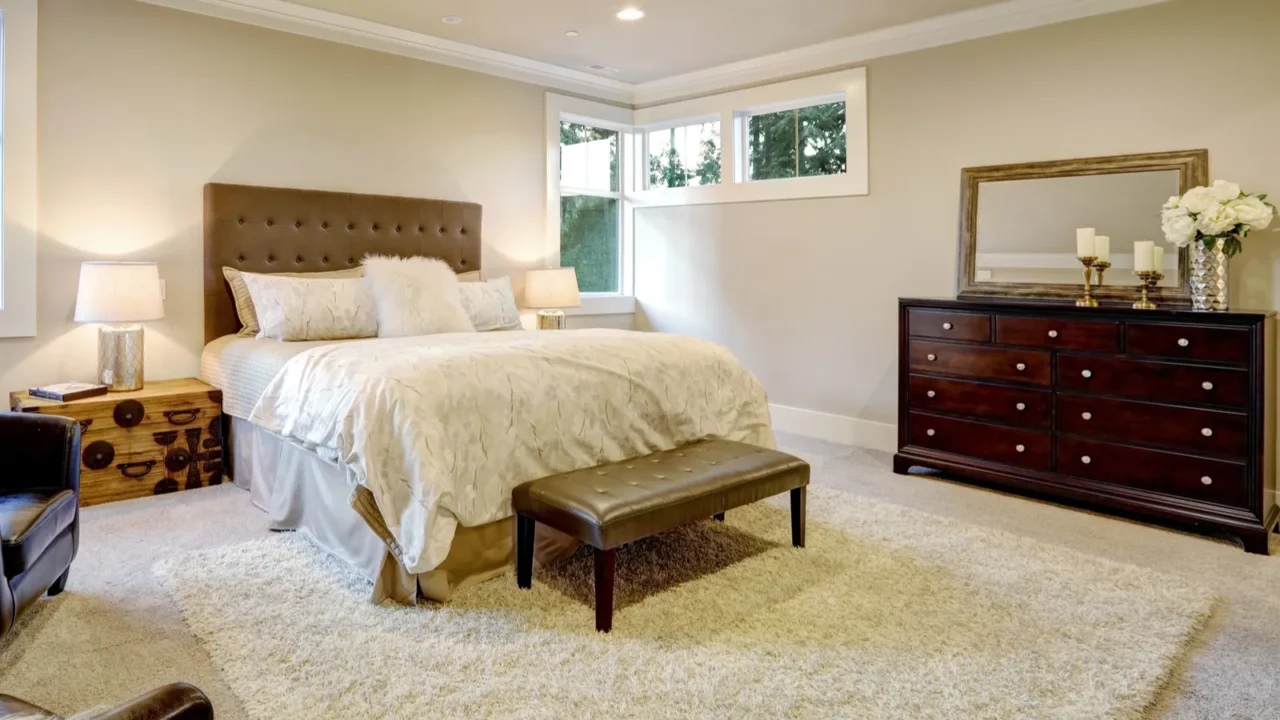 beige and brown master bedroom boasts tufted queen bed