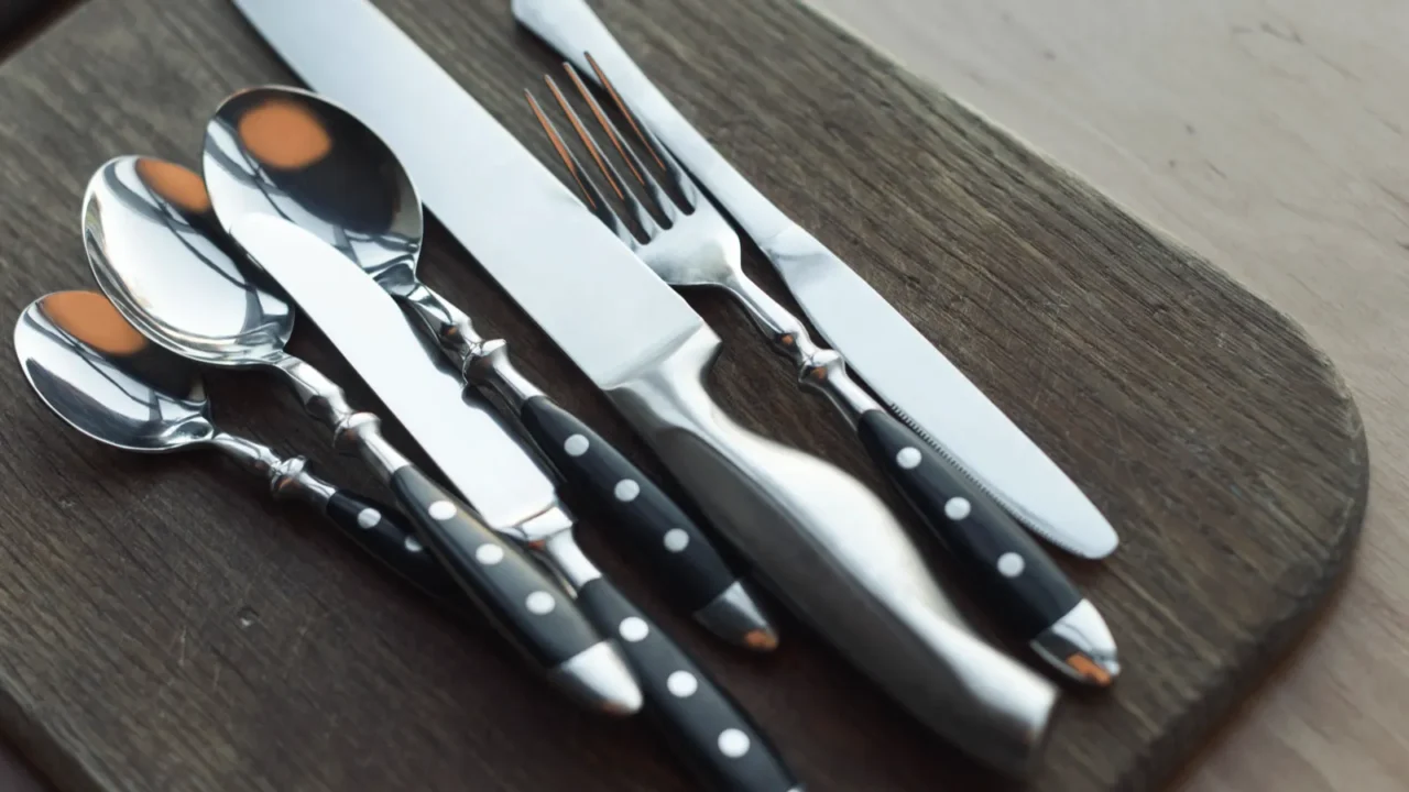 close up view of arrangement of steel dinnerware on wooden