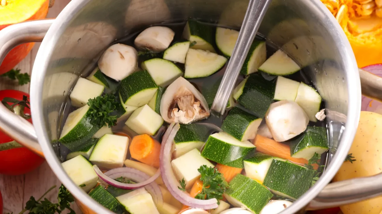 cooking pot with soup and ladle vegetables on table