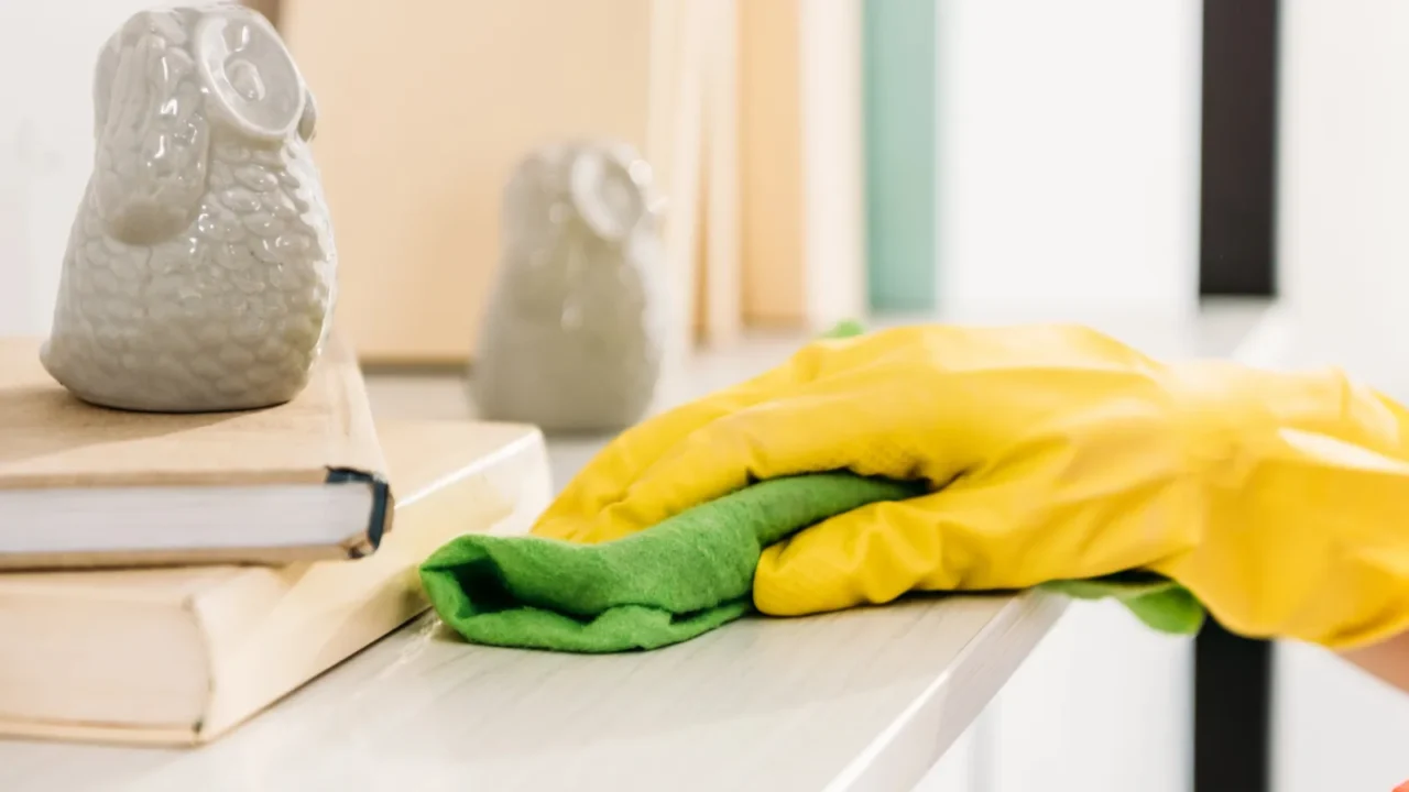 cropped view of woman in yellow rubber glove cleaning book