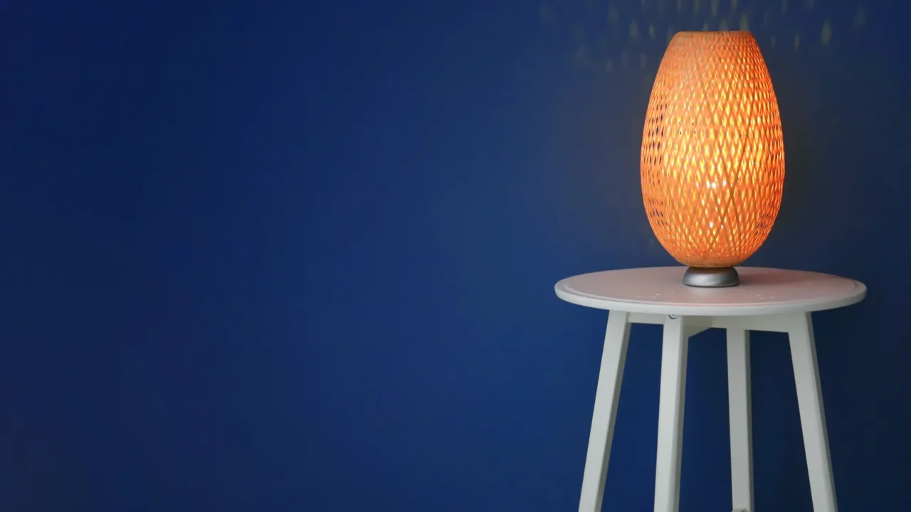 elegant lamp on table near color wall