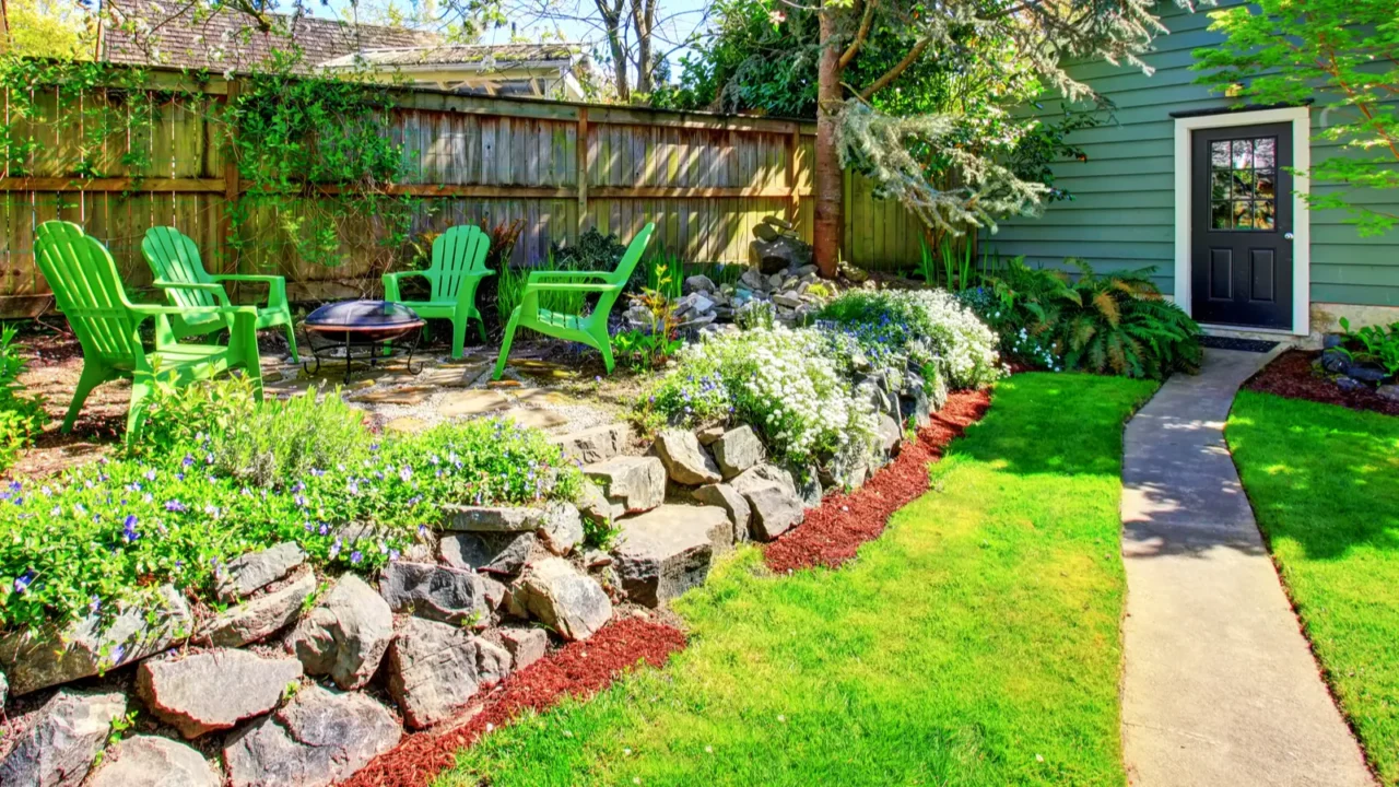 fenced backyard with green lawn and patio area view