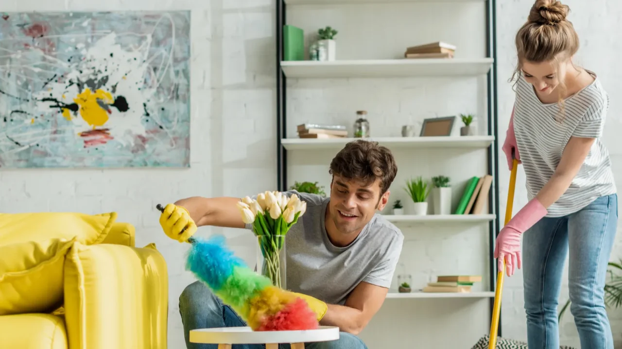 happy man and woman doing spring cleaning in apartment