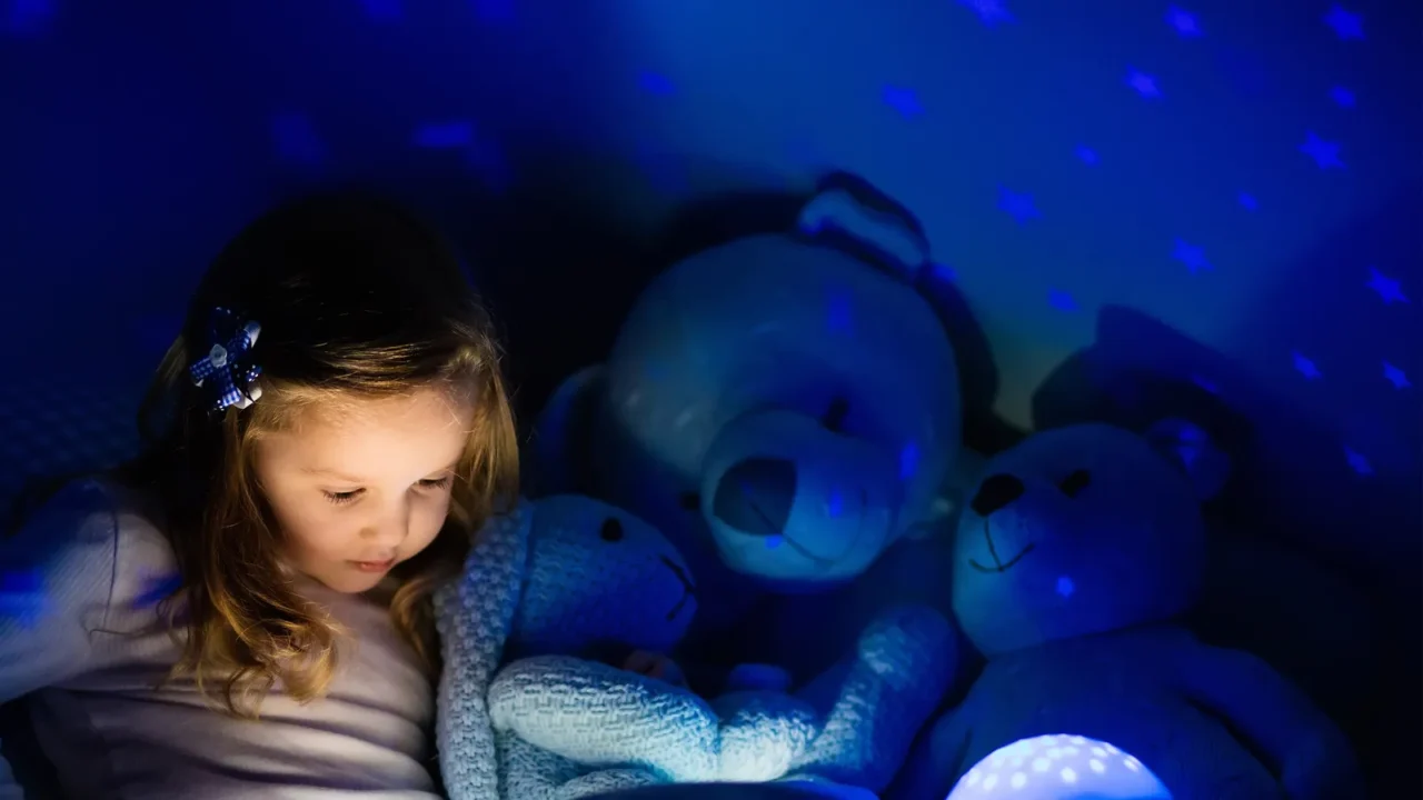 little girl in bed with night lamp