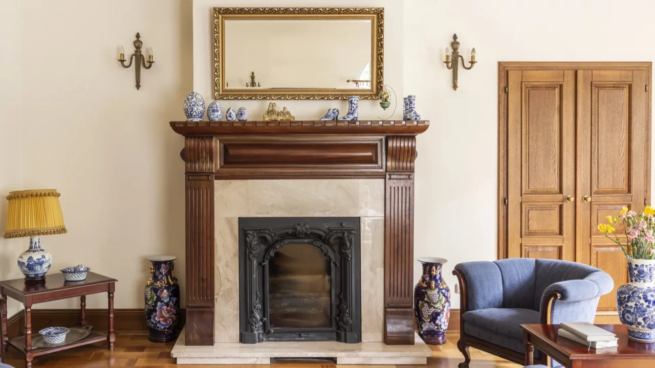 mirror in gold frame above fireplace in sophisticated living room