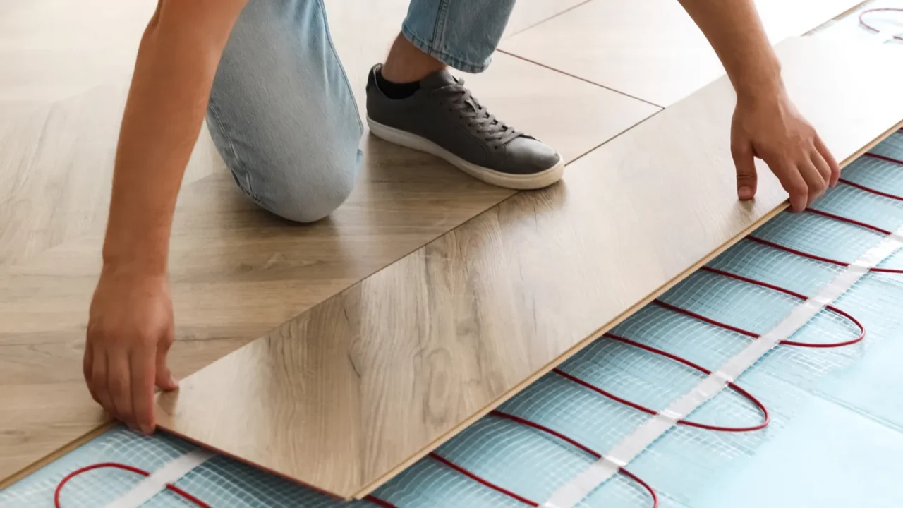 professional contractor installing underfloor trace heating system indoors closeup