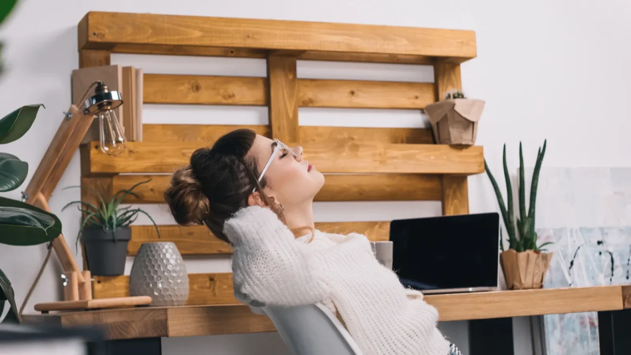 side view of girl stretching on chair in office