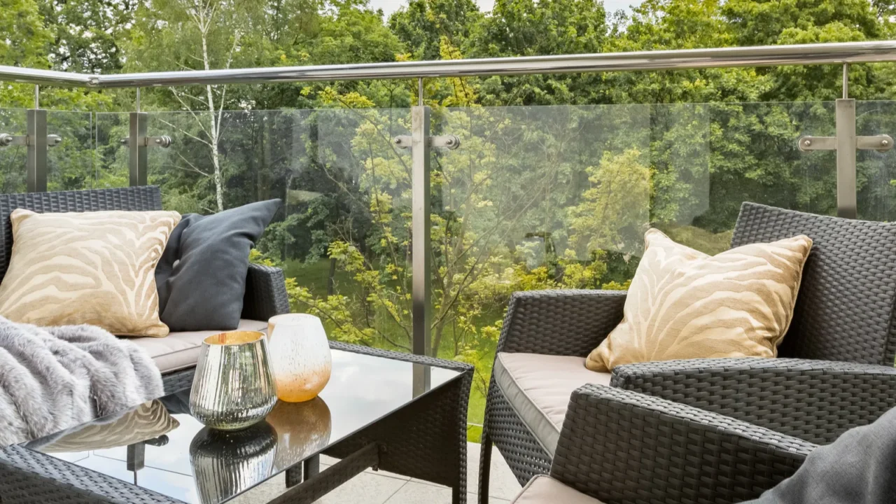 stylish balcony with elegant rattan furniture and glass walls and