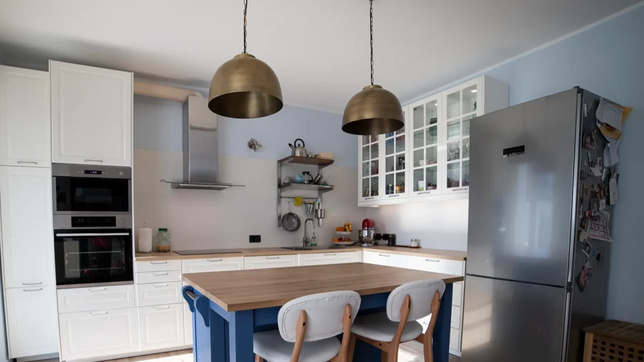 white bright scandi kitchen with blue island and double brass