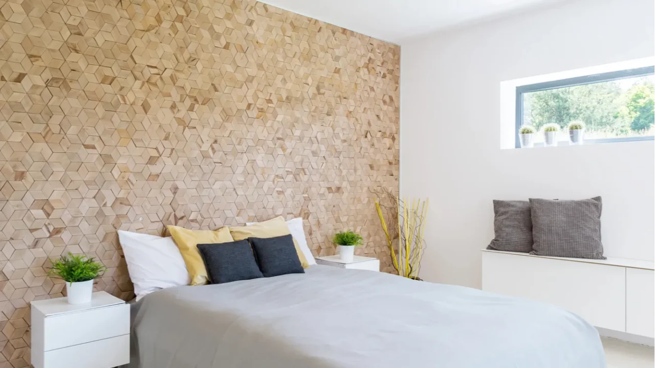 A monochromatic bedroom interior with wooden accent wall, cozy bed with throw pillows, and floating nightstands with small potted plants.