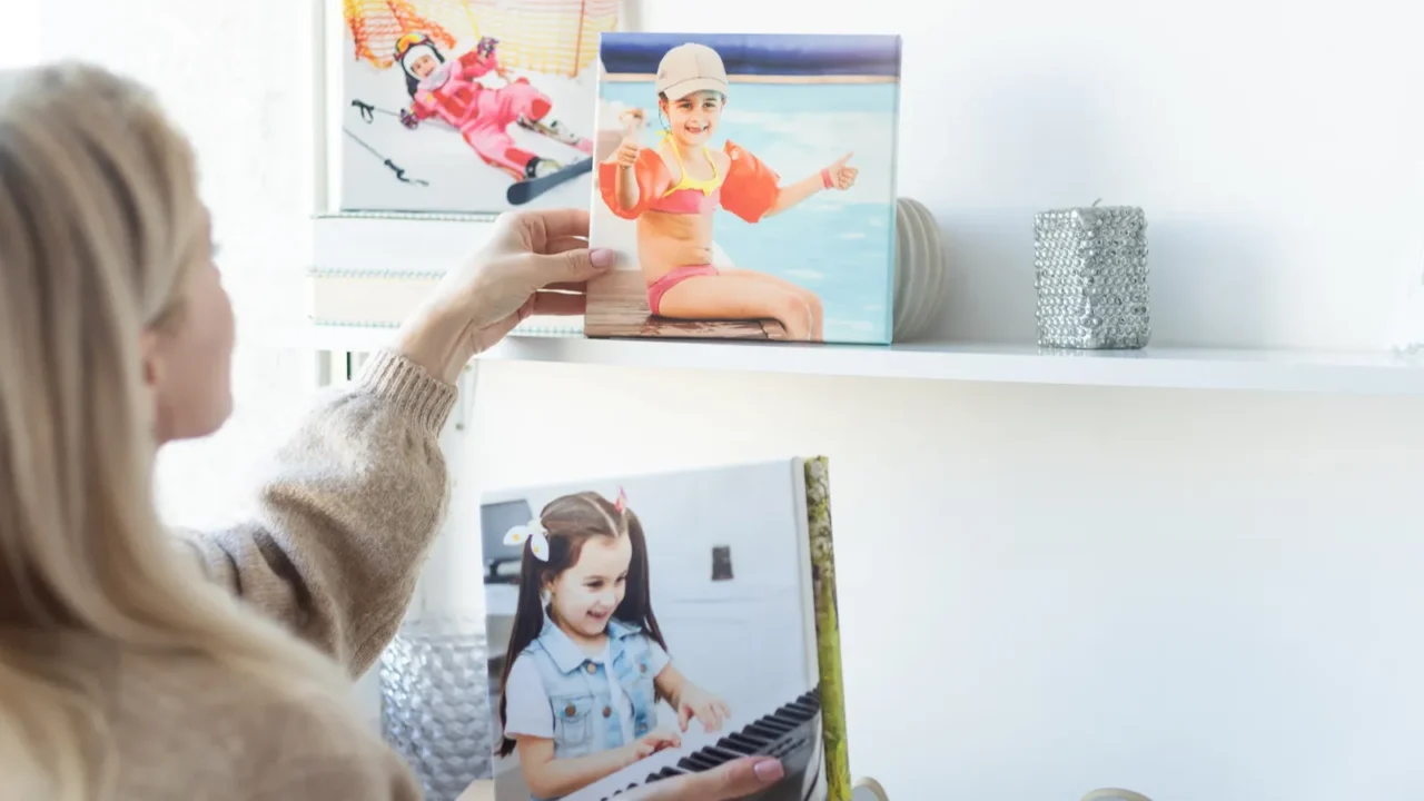 young woman hanging a photo canvas print painting on the