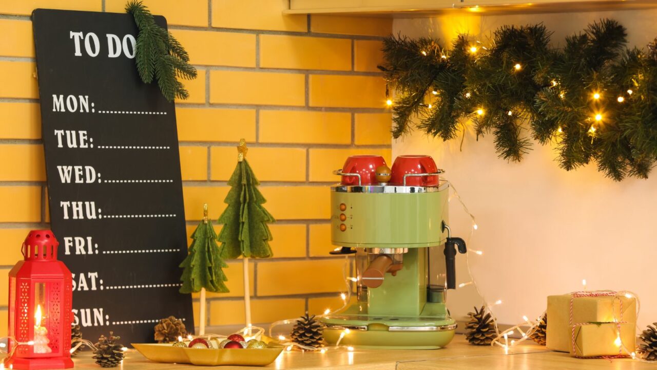 A cozy kitchen corner with a green espresso machine and decorative holiday elements.