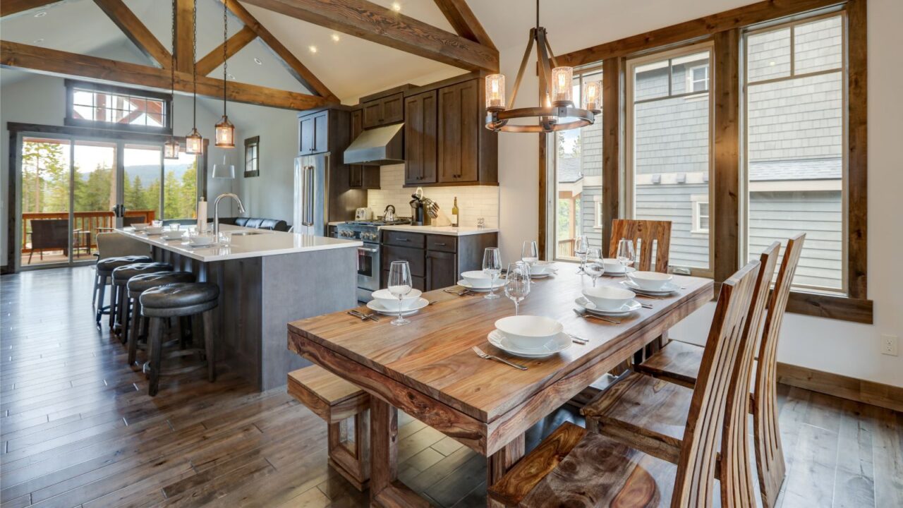 A spacious dining area with a wooden table, chairs, and a kitchen island nearby.