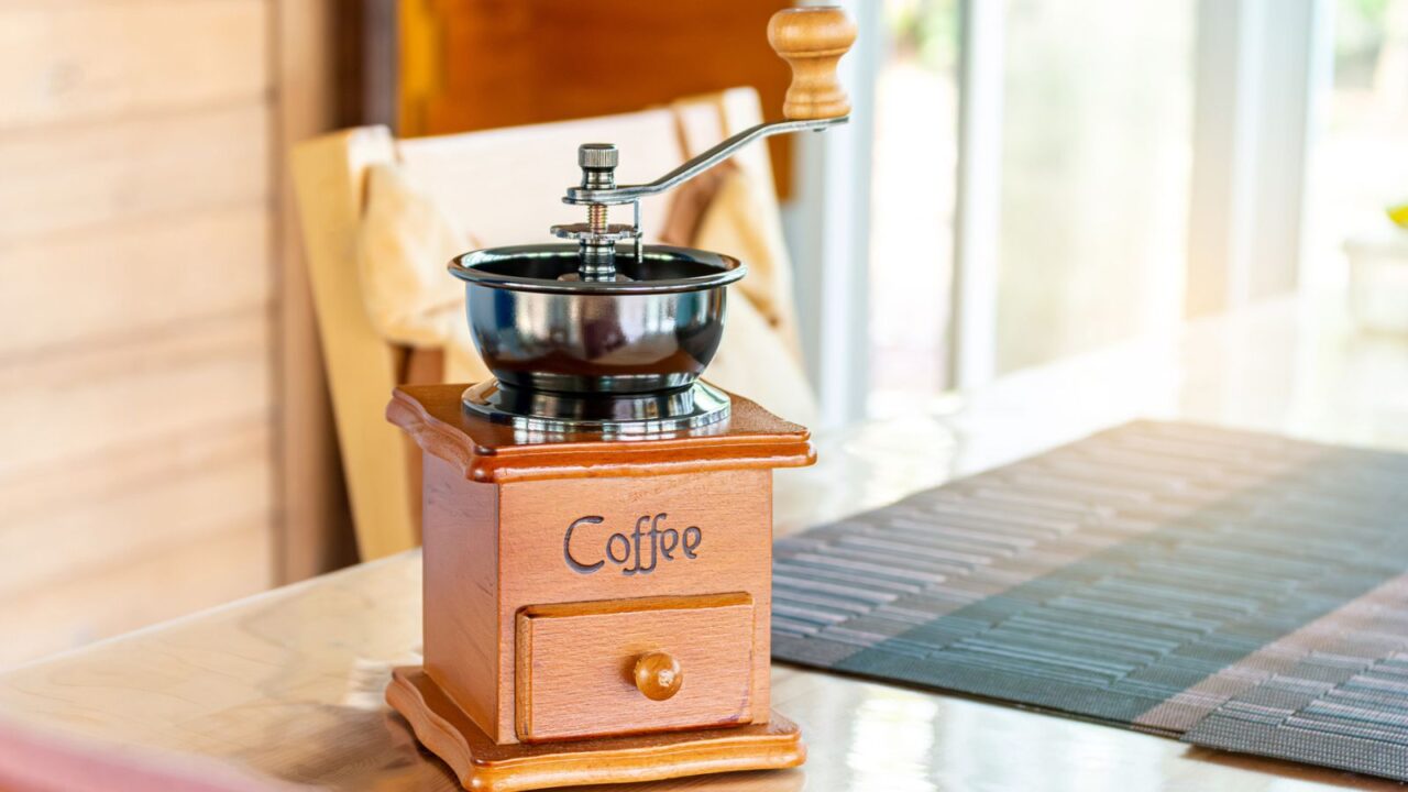 A vintage coffee grinder made of wood and metal, showcasing a rustic charm in a cozy setting.