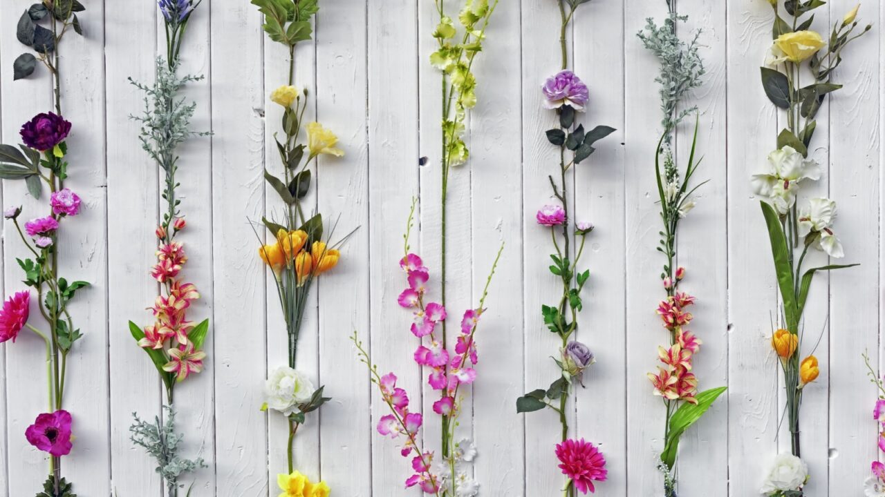 Bunches of colorful flowers on a white wall.