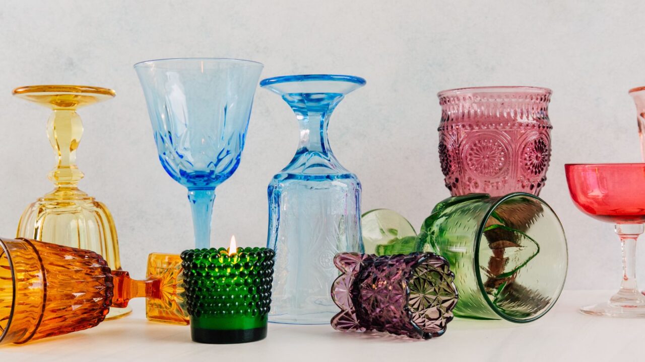 A set of different vintage glassware on a white surface.