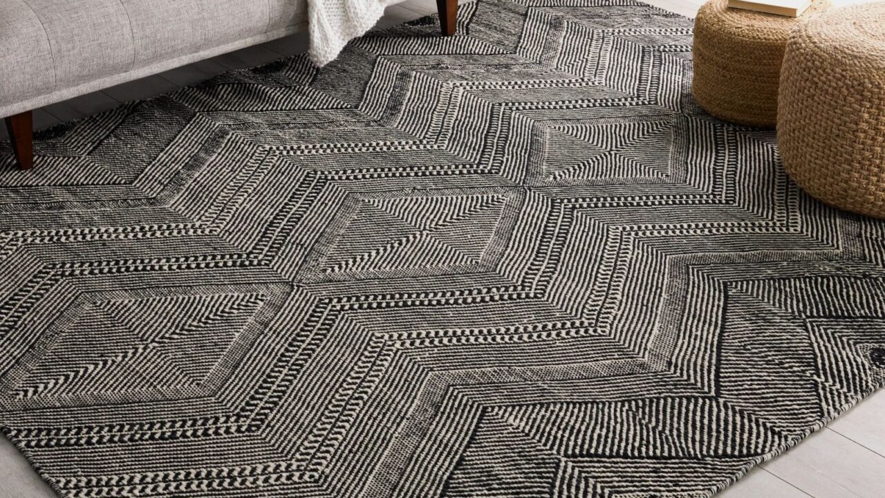 A black and white geometric flat-weave washable rug in modern living room.