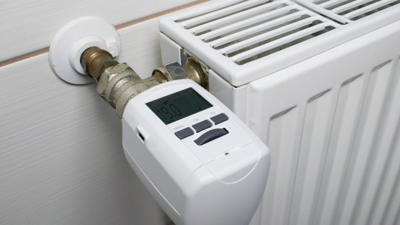 A thermostatic radiator valve attached on the wall displaying a temperature of 19.0 degrees Celsius.