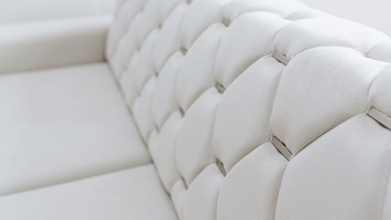 A cozy white sofa with geometric patterns on it.