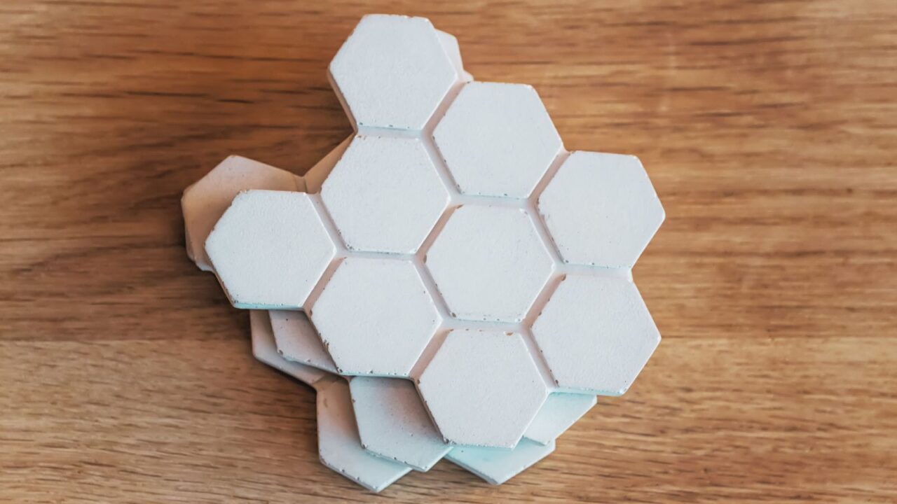 White honeycomb table coasters on a wooden table.