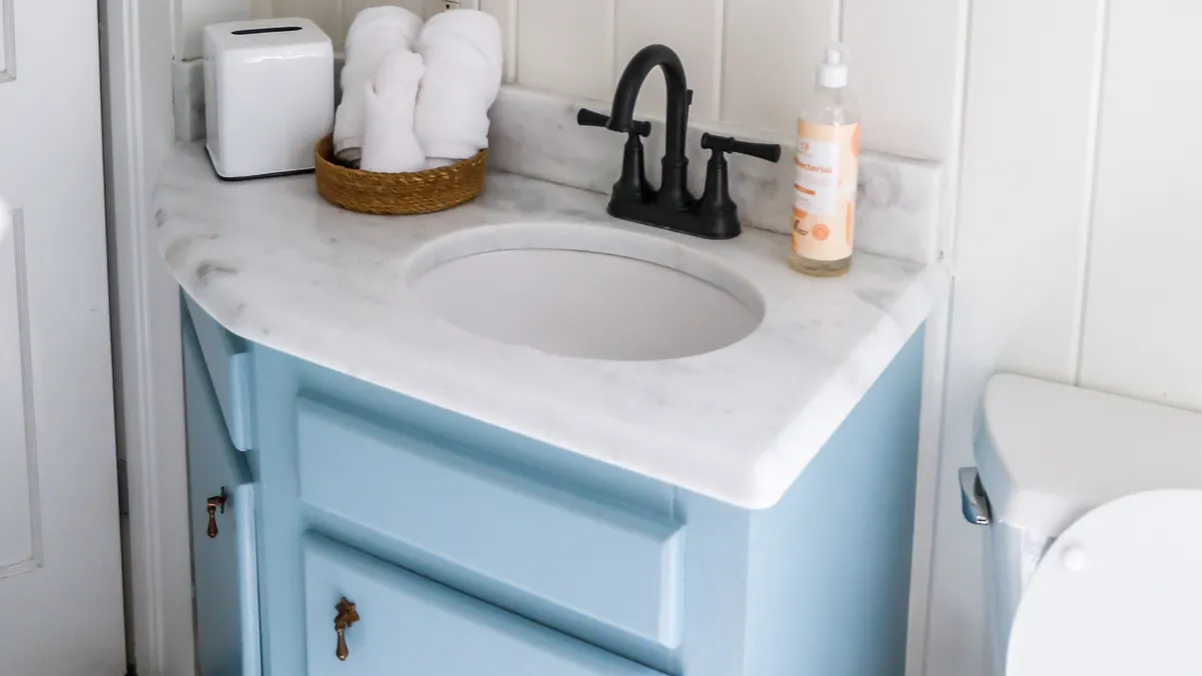 a small guest bathroom with a vintage blue vanity retro