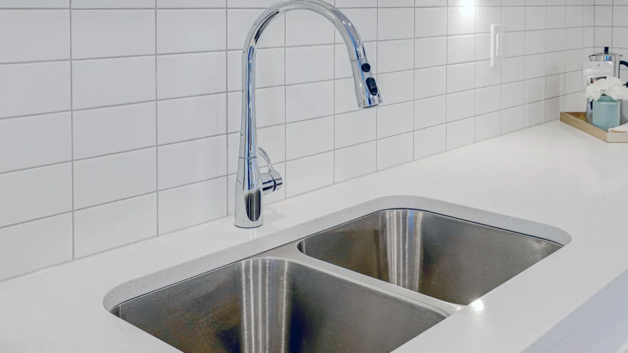 a stainless steel sink with a silver faucet sits on