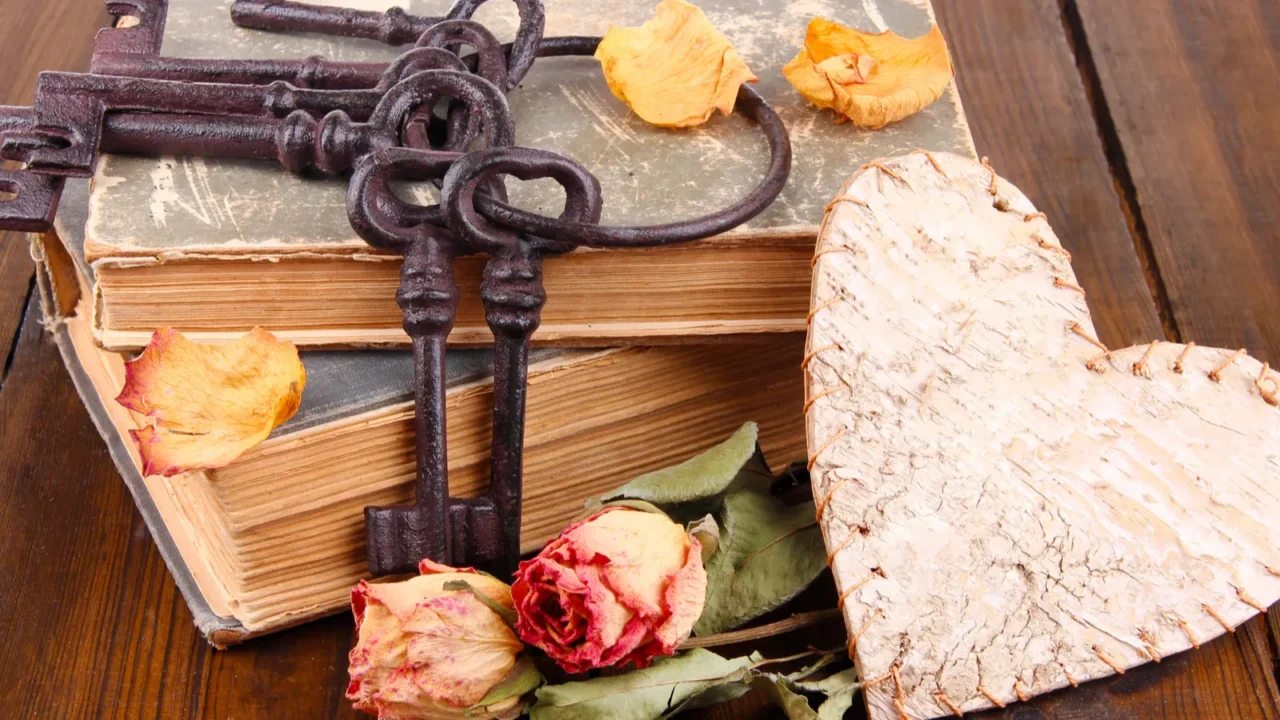 beautiful composition with old key and old books on wooden