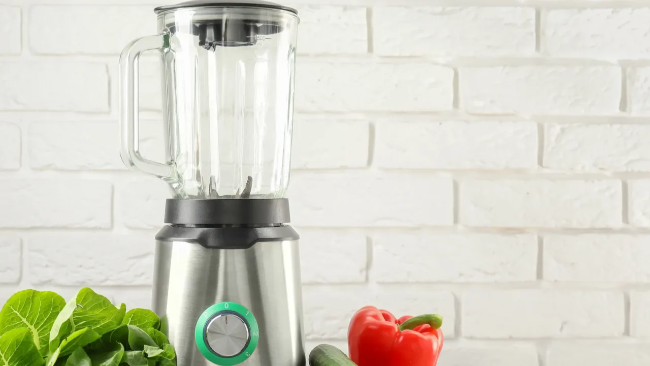 blender and products on light table against white brick wall