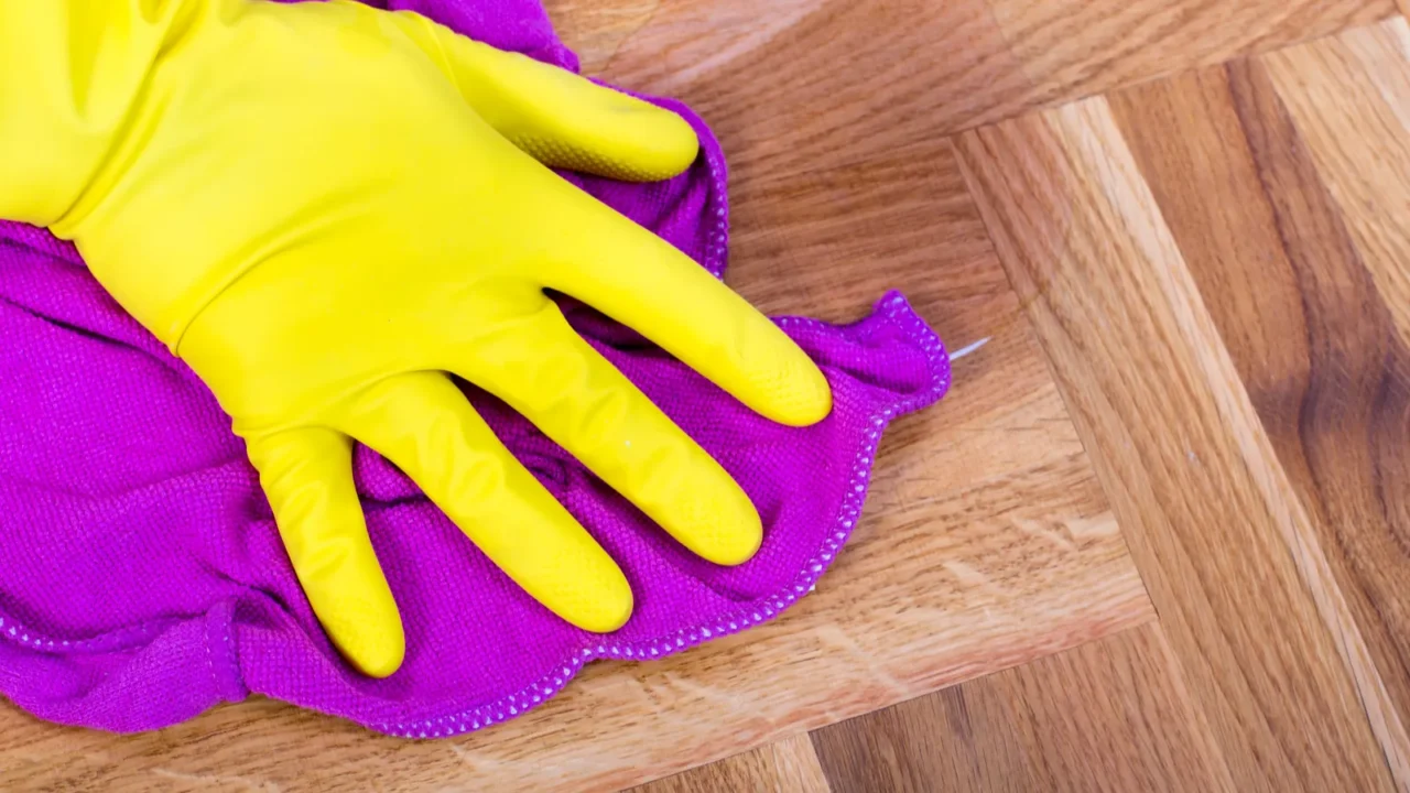 close up of females hand with protective gloves wiping parquet