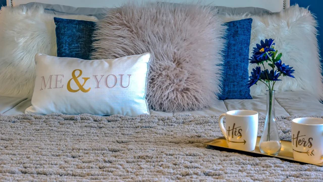 couple bed with pillows and mugs on a tray